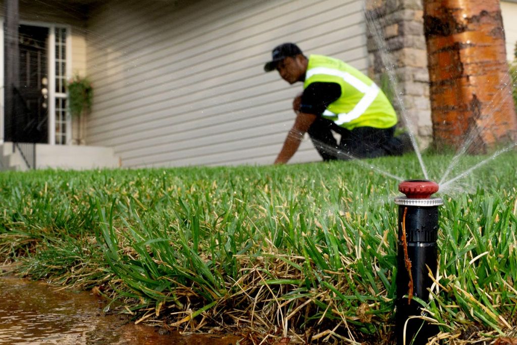 Rotor nozzle on a spray body sprinkler head in a green lawn with naiad irrigation systems service technician copy 1024x683